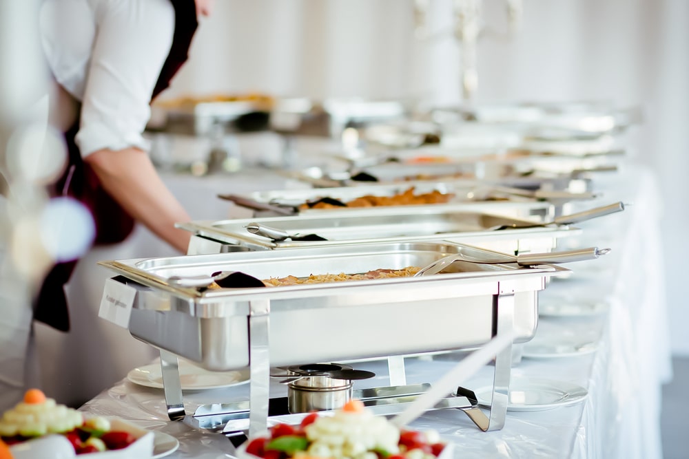 catering served on table with worker setting up more plates